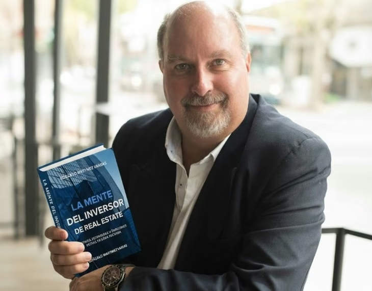 Gonzalo Martínez Vargas sosteniendo uno de sus libros